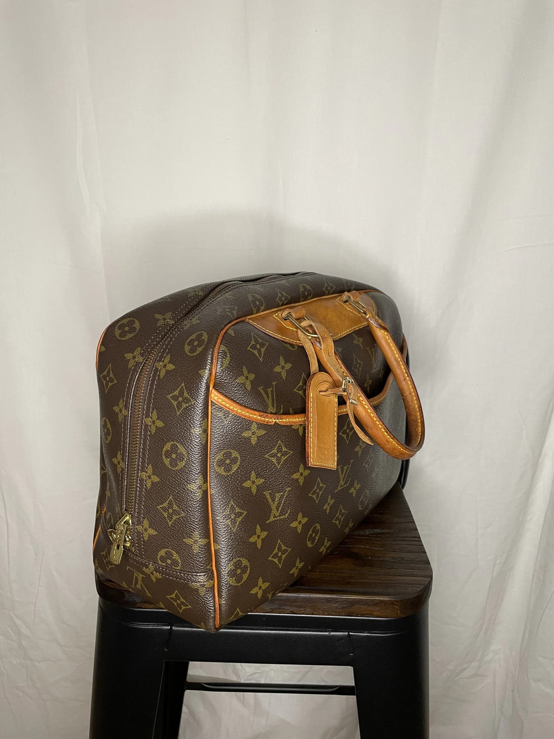 Sac Deauville présenté de trois-quarts sur un tabouret